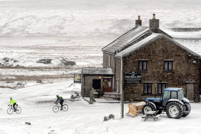 a128-hardy-cyclists-brave-the-winter-weather-on-tan-hill-while-the-inns-snowplough-stands-ready-for-action